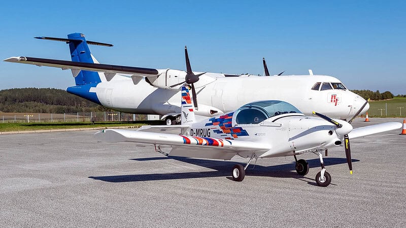 Ein Pioneer 200 Flugzeug steht vor einem Transport Flugzeug