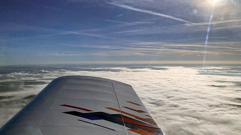 Flügel eines Pioneer 200 Flugzeuges über den Wolken