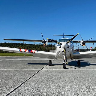 Ein Pioneer 200 Flugzeug steht vor einem großen Flugzeug am Flughafen