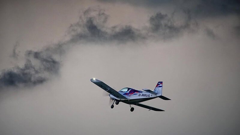 das Flugzeug Pioneer 200 welches zwischen Wolken fliegt