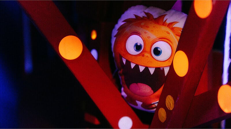 Ein Monster Kissen zwischen Balken was Freundlicht schaut und seine Zähne zeigt