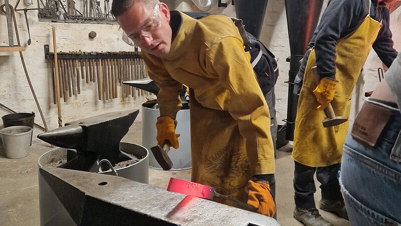 Person schaut sich seine Schmiedekunst an.