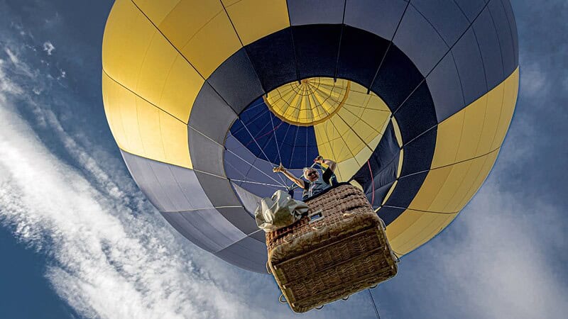 winkende Frau aus dem Korb eines Ballons