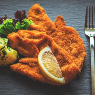 Ein Schnitzel mit Zitrone und Kartoffeln aus der Nähe Fotografiert.