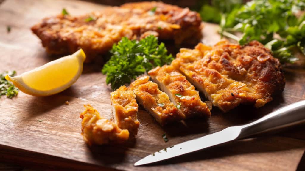 Schnitzel-Büfett- geschnittenes Schnitzel Ein Schnitzel was auf einem Holzbrett in Streifen geschnitten wurde.