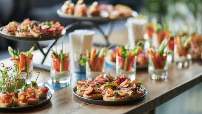 Tisch mit Platten die voll mit kleinen Belegten Brotscheiben sind.