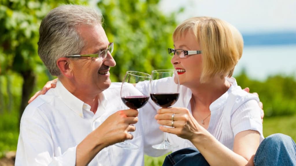Ein Paar stößt mit einem Glas Rotweit an - Weinwanderung.