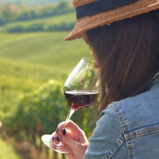 Eine Frau verkostet einen Wein bei einer Weinwanderung.