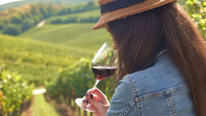 Eine Frau verkostet einen Wein bei einer Weinwanderung.