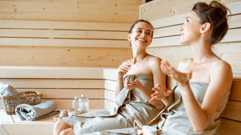 Zwei Frauen die sich in einer Sauna unterhalten.