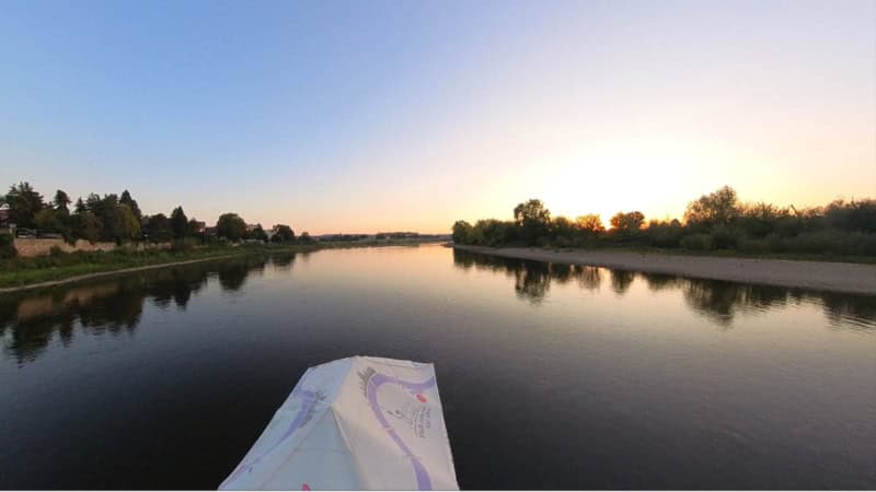 Floß fährt bei Sonnenaufgang auf der Elbe