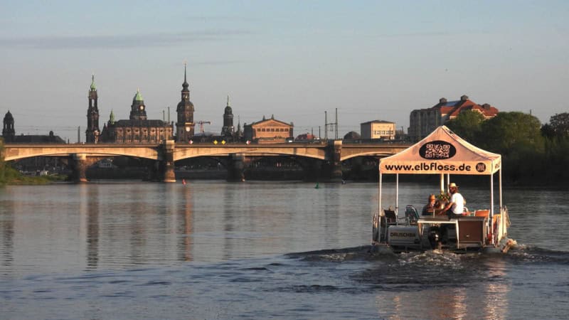 Floß fährt auf der Elbe an der Marienbrücke vorbei.